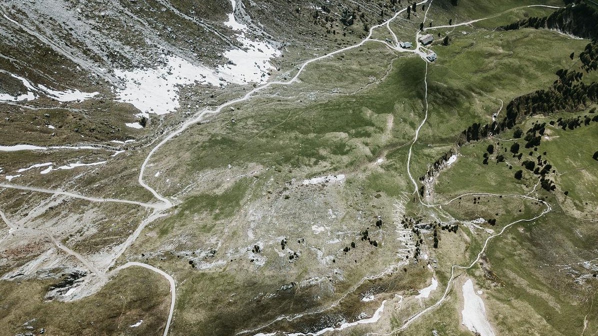 person using Google Maps on phone in remote area of Lhasa, confused expression, mountainous terrain, outdated navigation