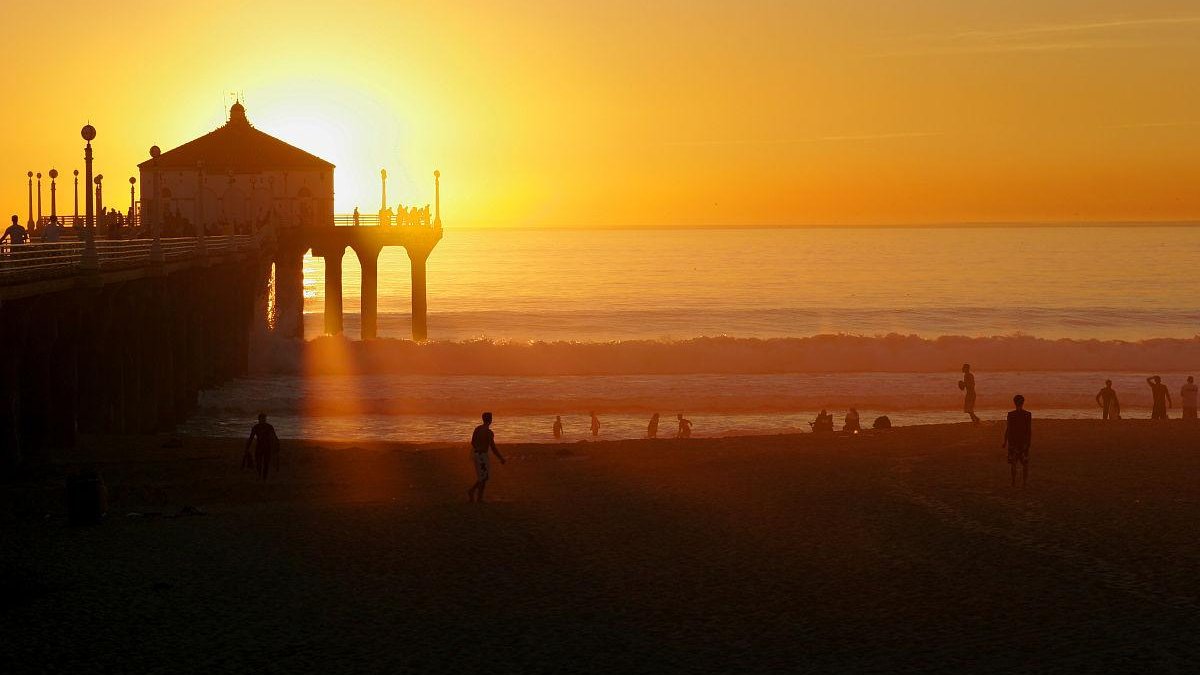 traveler sitting on quiet city rooftop watching sunset with local people