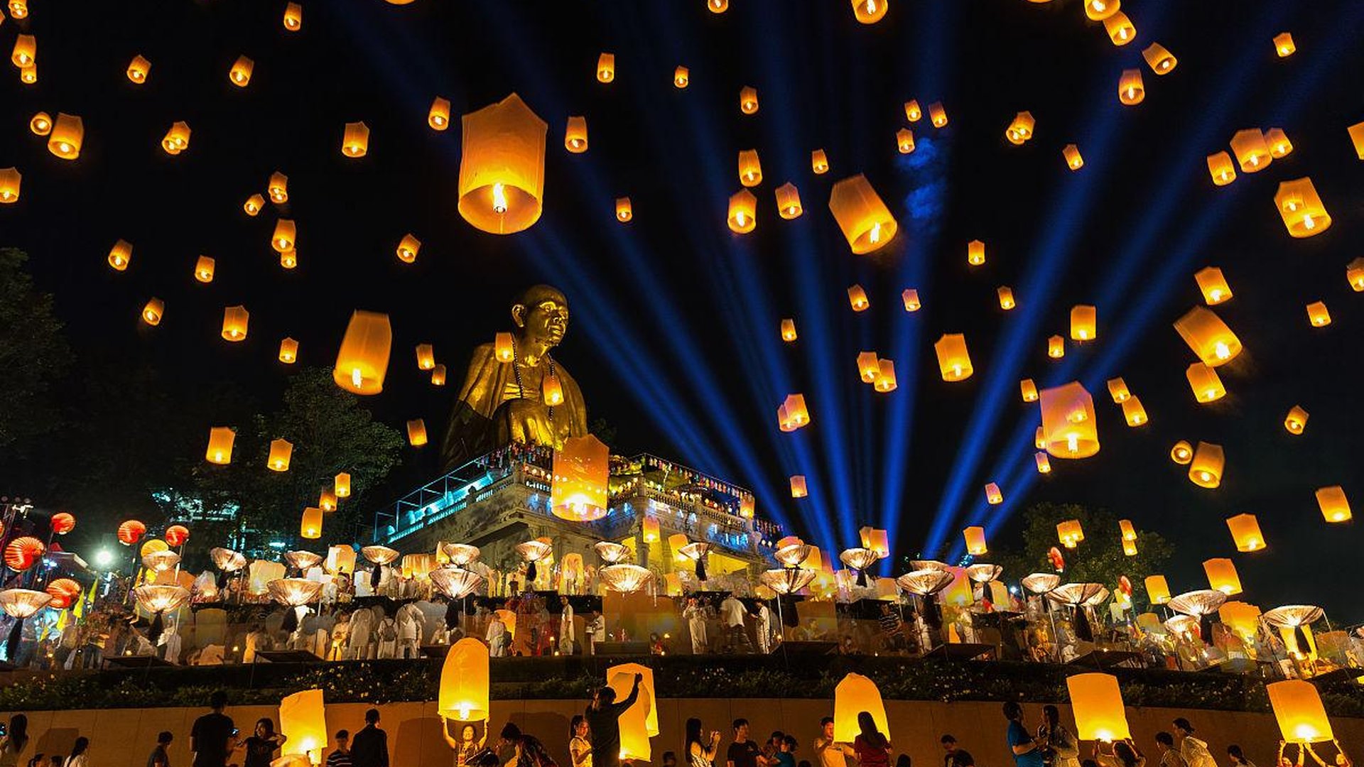 Thai temple at night glowing with lanterns, monsoo