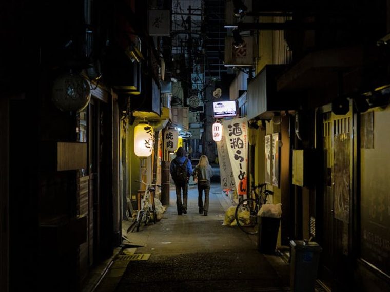 A traveler walks down a crowded city sidewalk into a quiet