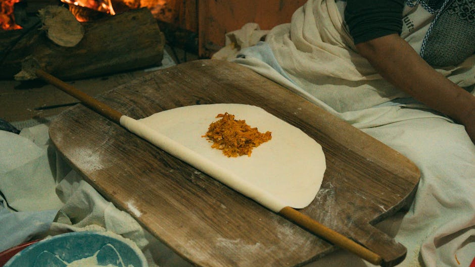 a small family-run kitchen in Oaxaca, Mexico, with traditional cooking tools, handmade tortillas, and a grandmother preparing mole sauce, warm sunlight, rustic atmosphere